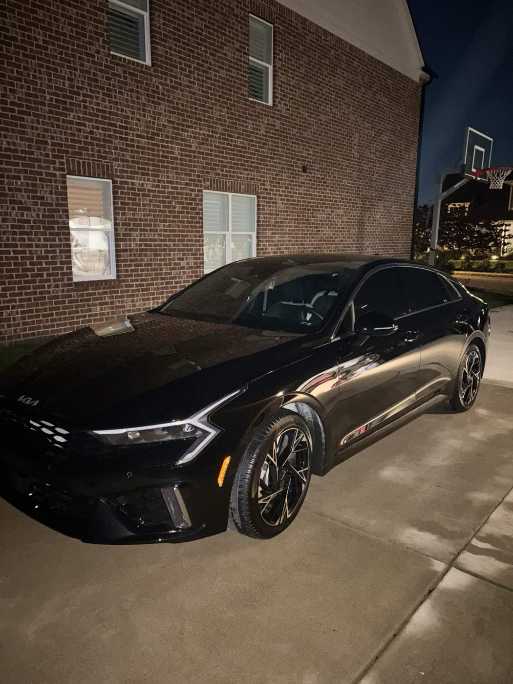 Black Kia K5 sedan detailed to a high gloss, evening photo, by JDM Detailing